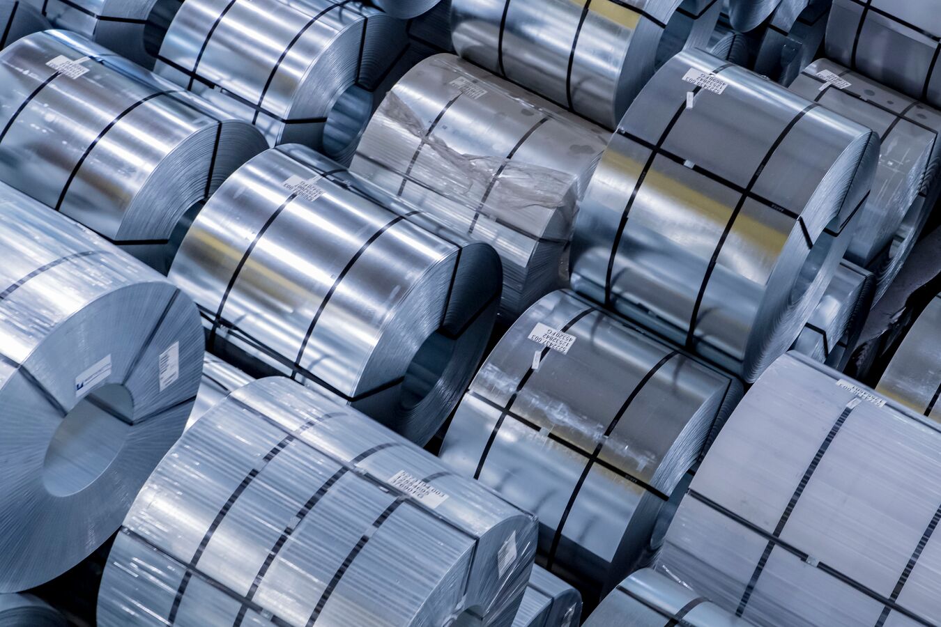 Stacks of banded and wrapped galvanized steel in a facility.