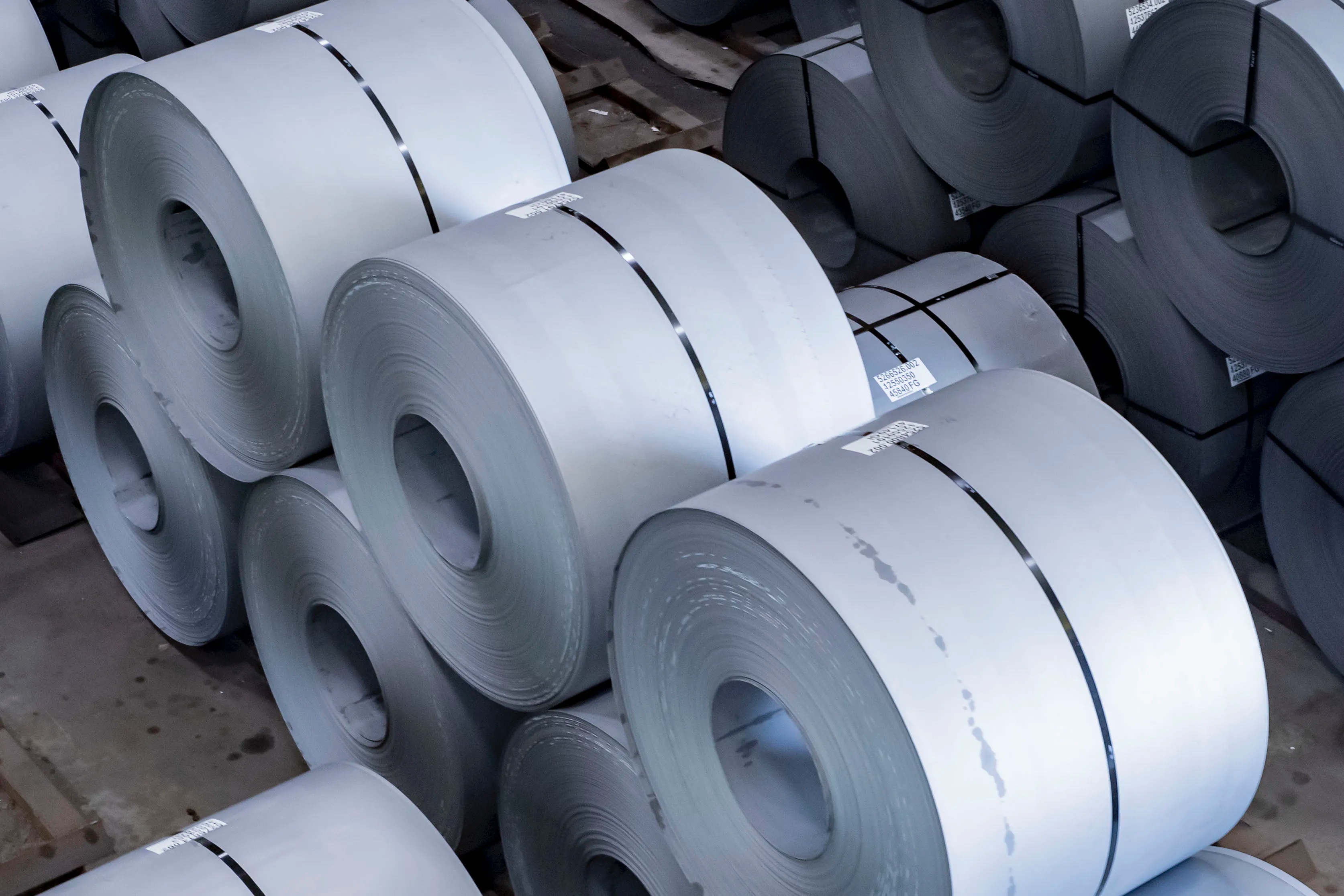 Two stacks of cold rolled steel coils with bands on a facility floor.