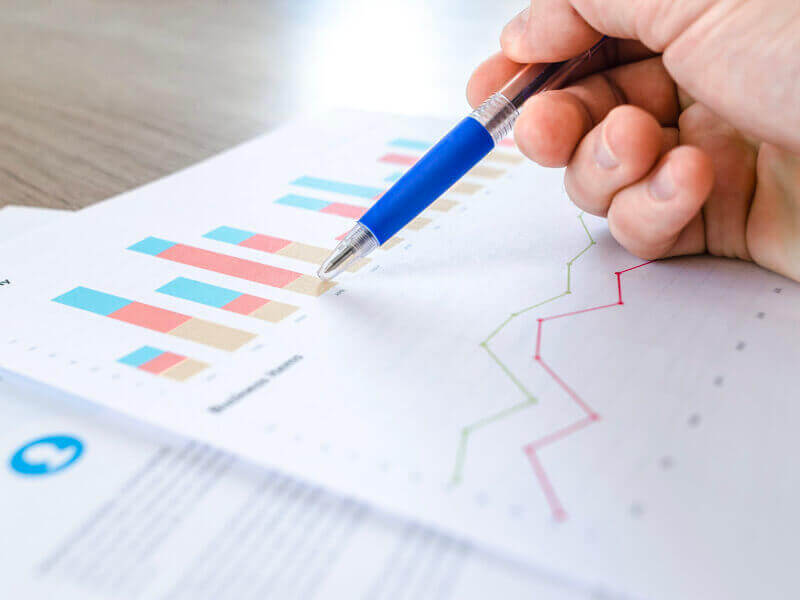 A document on a desk with colorful bar graphs and line charts.