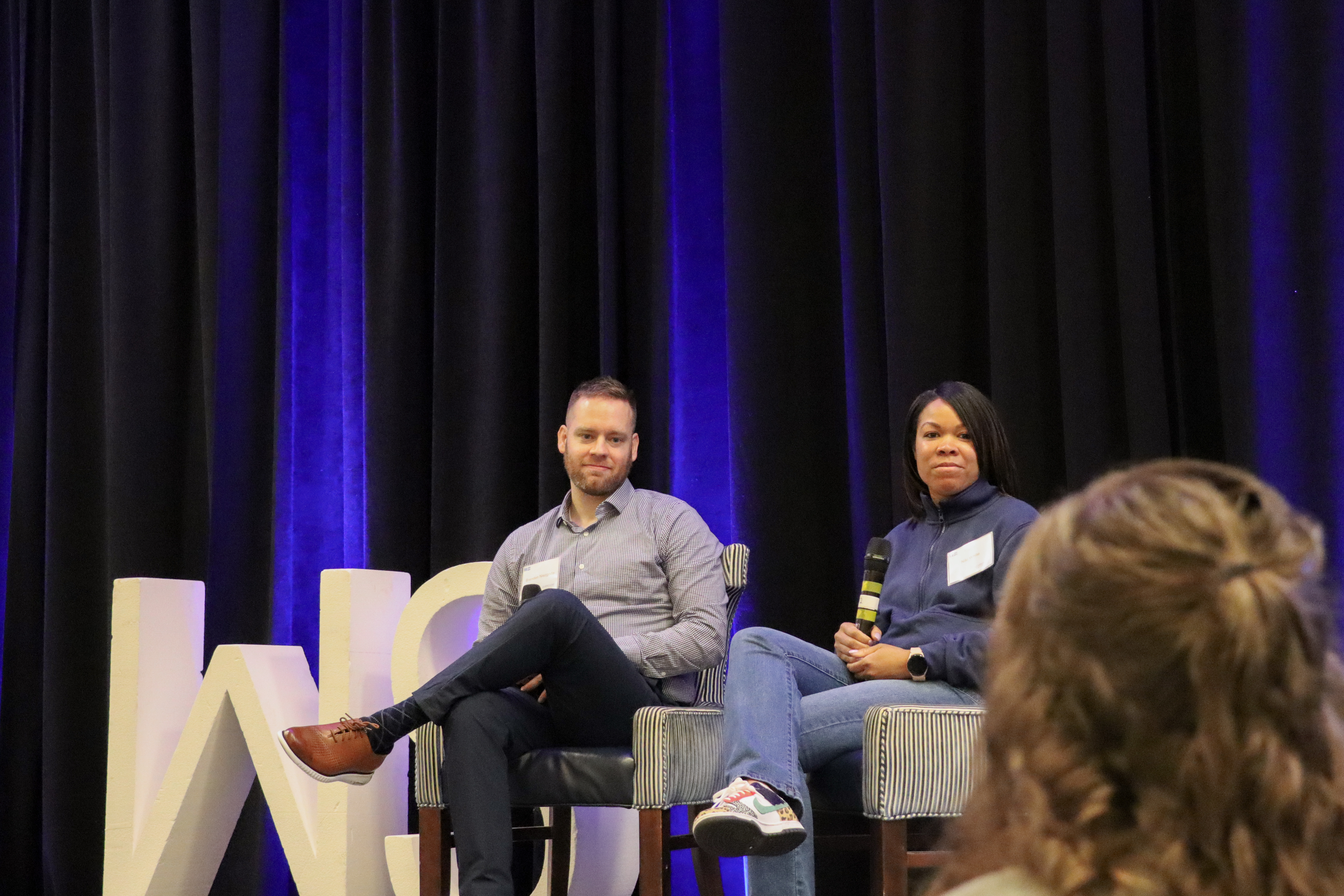 Worthington Steel employees speaking on stage during a company conference.
