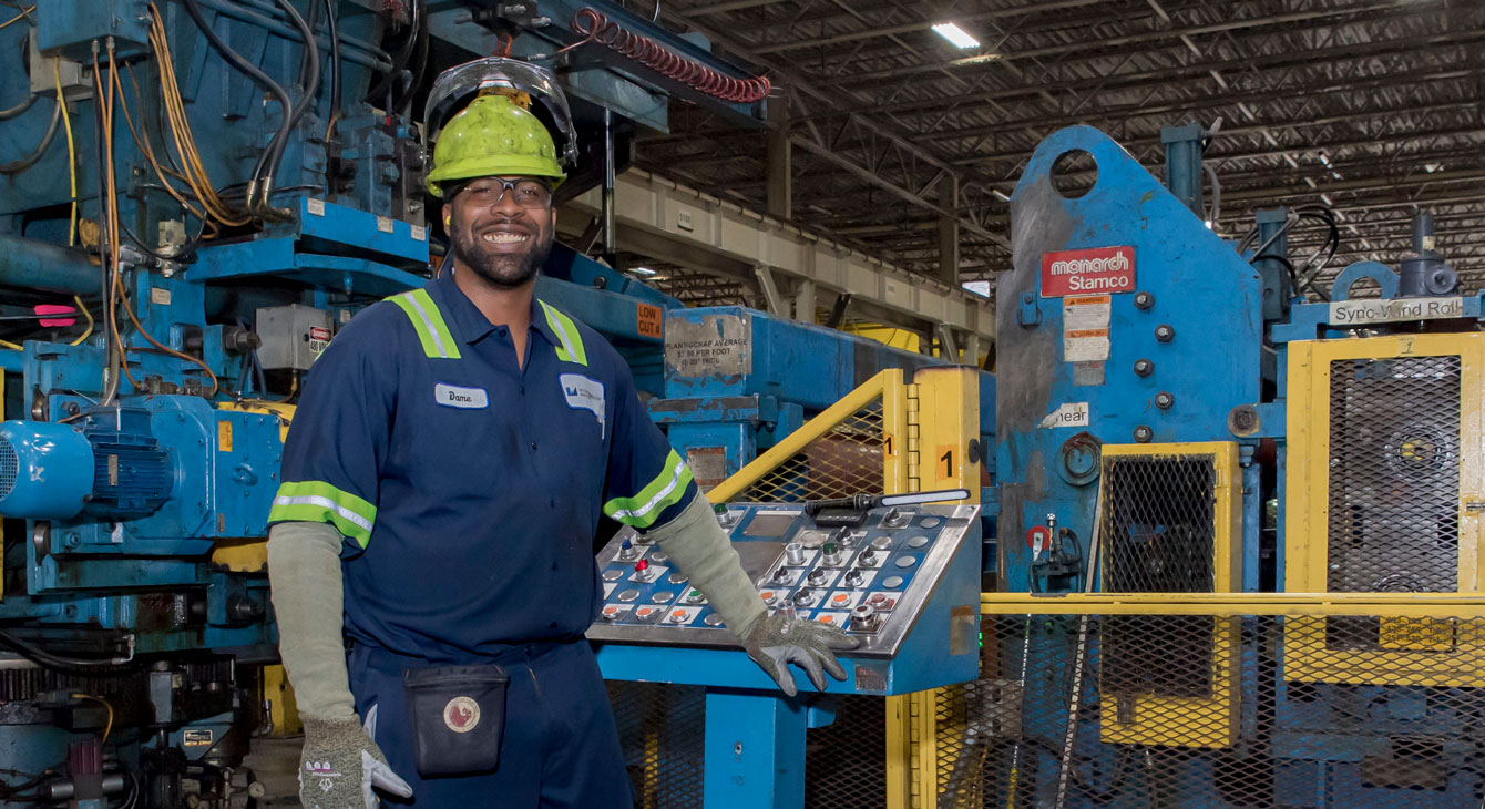 Worthington Steel employee operating machinery on the production floor of a steel processing facility.