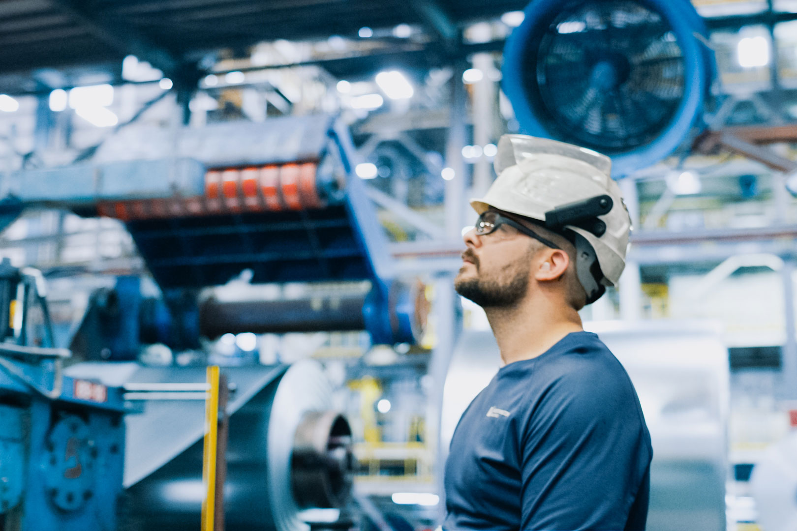 Factory employee looking up at machinery